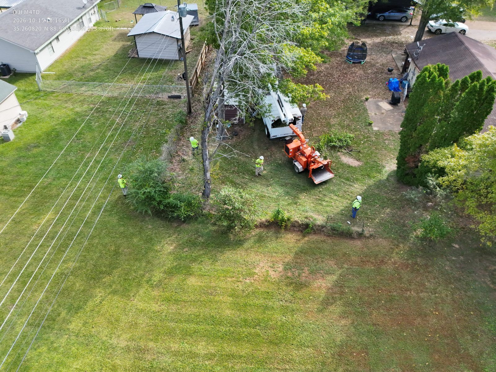 The Right Of Way Crew working beneath power lines in a residential yard